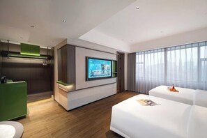 A modern hotel room with a flat-screen TV, a green minibar, a white sofa, and a large window. - Haoyi Hotel (Zhuzhou)
