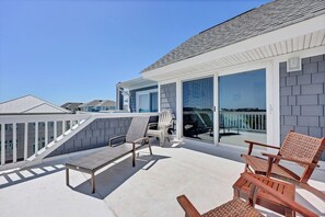 A balcony with a white railing, two wicker chairs, and a wooden chair. - Wonderful Ocean View Condo on Wrightsville Beach (Wrightsville Beach)