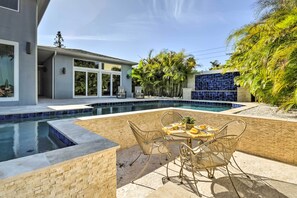 A modern house with a swimming pool, outdoor seating, and tropical plants. - Expansive St Pete Beach Home: Pool, Walk to Beach (St Pete Beach)