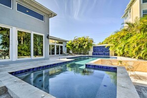 A modern house with a swimming pool, large windows, and a patio area. - Expansive St Pete Beach Home: Pool, Walk to Beach (St Pete Beach)