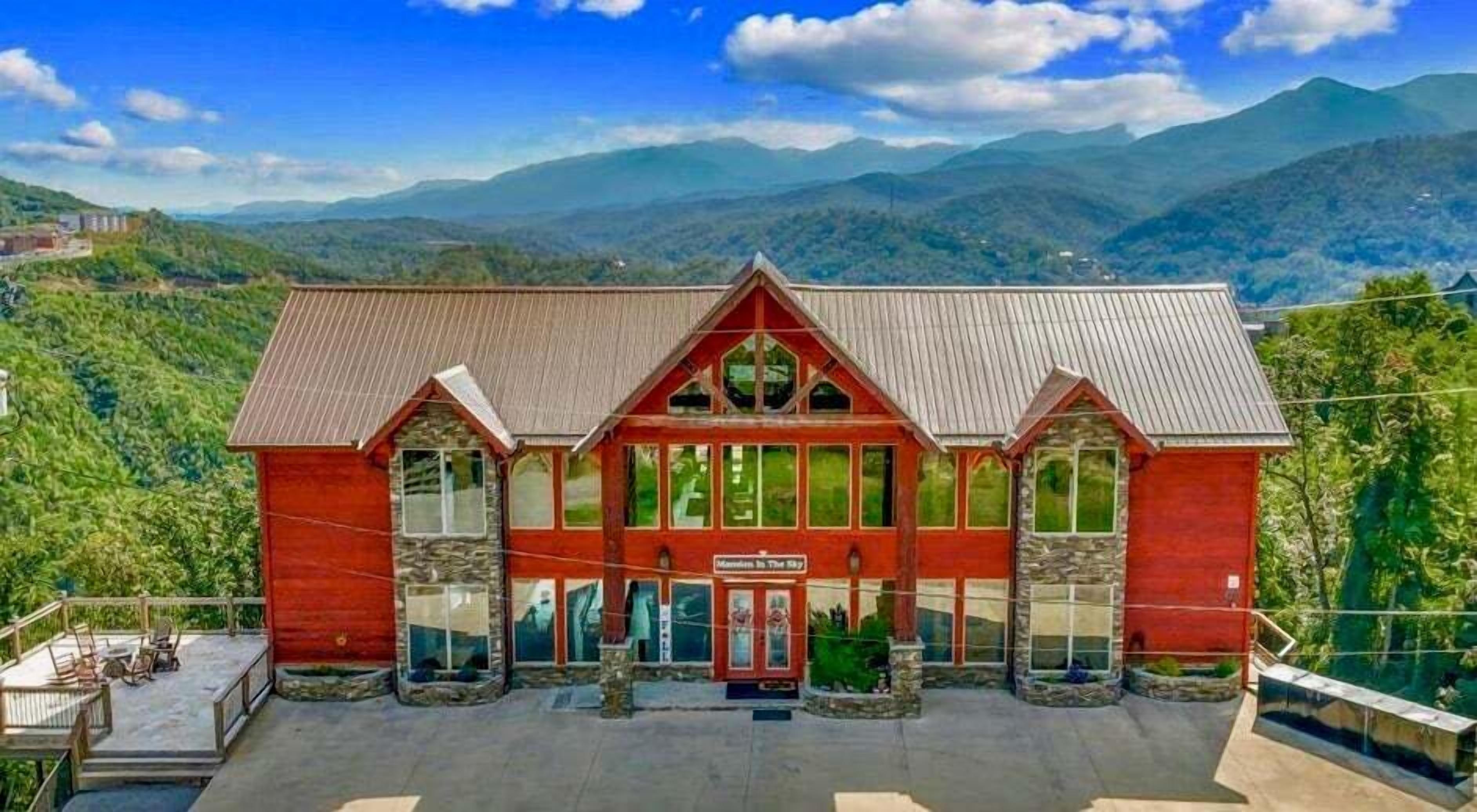 A red building with a stone facade, large windows, and a sign that reads "Mansions in the Sky."