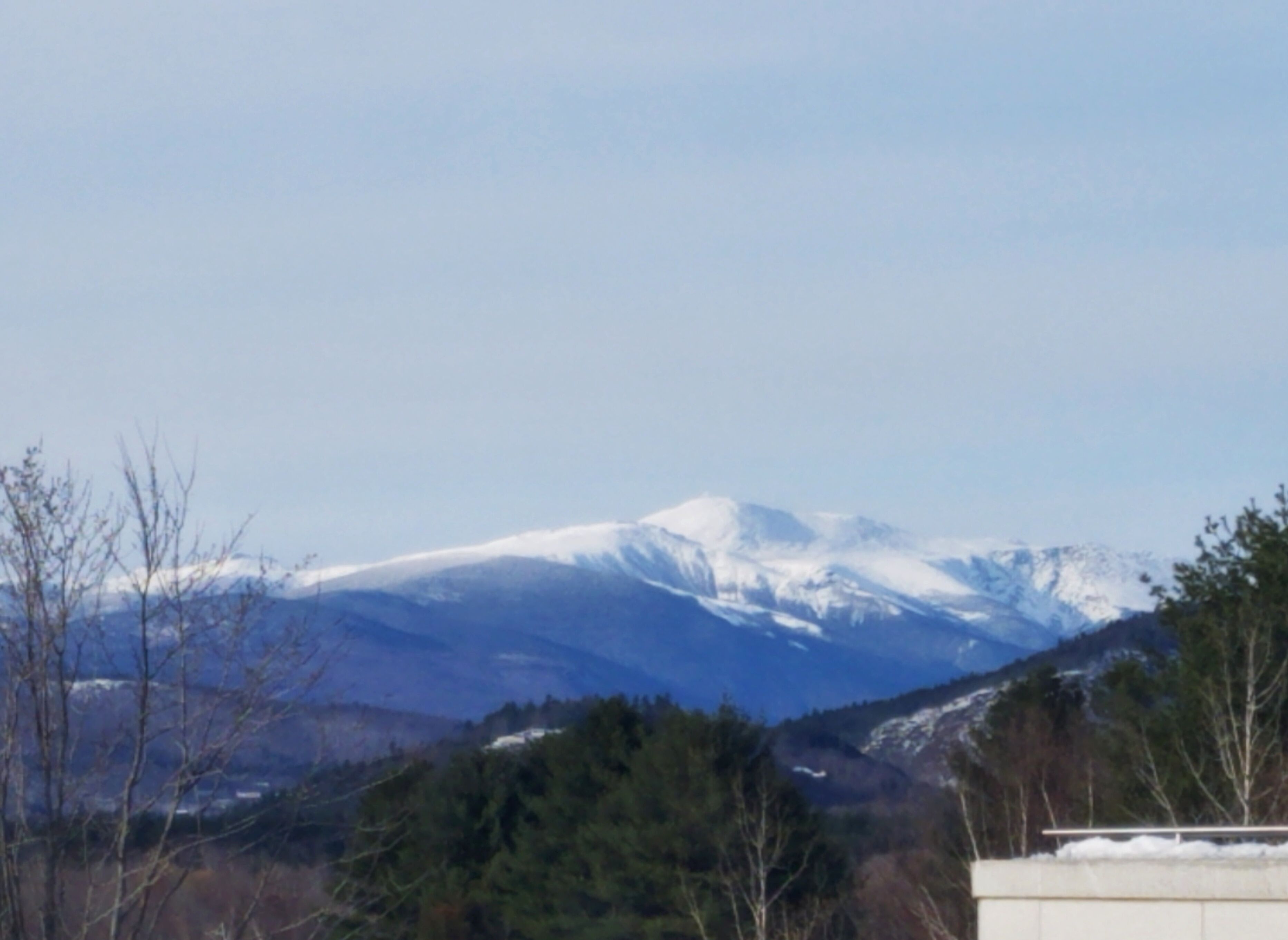 A mountain range with snow-capped peaks and a clear sky.