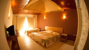 Una camera d'albergo con un letto grande, una scrivania, una sedia, un comodino e una TV.