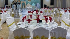 A banquet hall with round tables set for a formal event, adorned with white tablecloths and red napkins. - Lvzhiyun International Hotel (Liuyang)