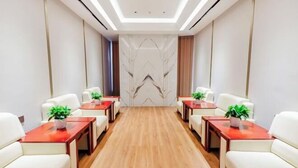 A conference room with a long table, white chairs, and potted plants. - Lvzhiyun International Hotel (Liuyang)