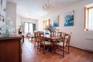 A dining area with a wooden table, chairs, and a chandelier. - Self catering Puerta del Agua for 4 people (Uclés)