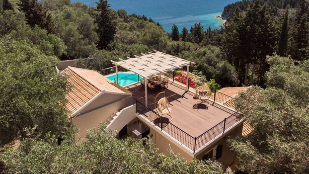 Una villa con piscina, zona de estar al aire libre y vistas al mar.