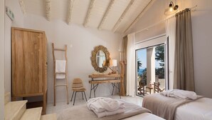 Un dormitorio con dos camas, un escritorio de madera, una silla, una escalera y vistas al exterior.
