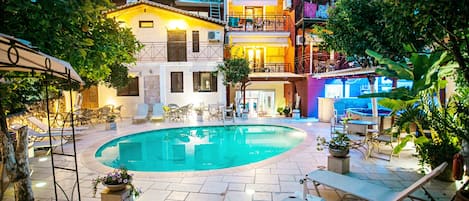 Una piscina al aire libre de temporada, sombrillas