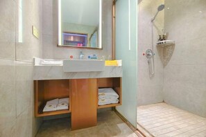 A bathroom with a marble sink, wooden shelves, a mirror, and a shower area. - Kailong Hot Spring Hotel (CHENZHOU)