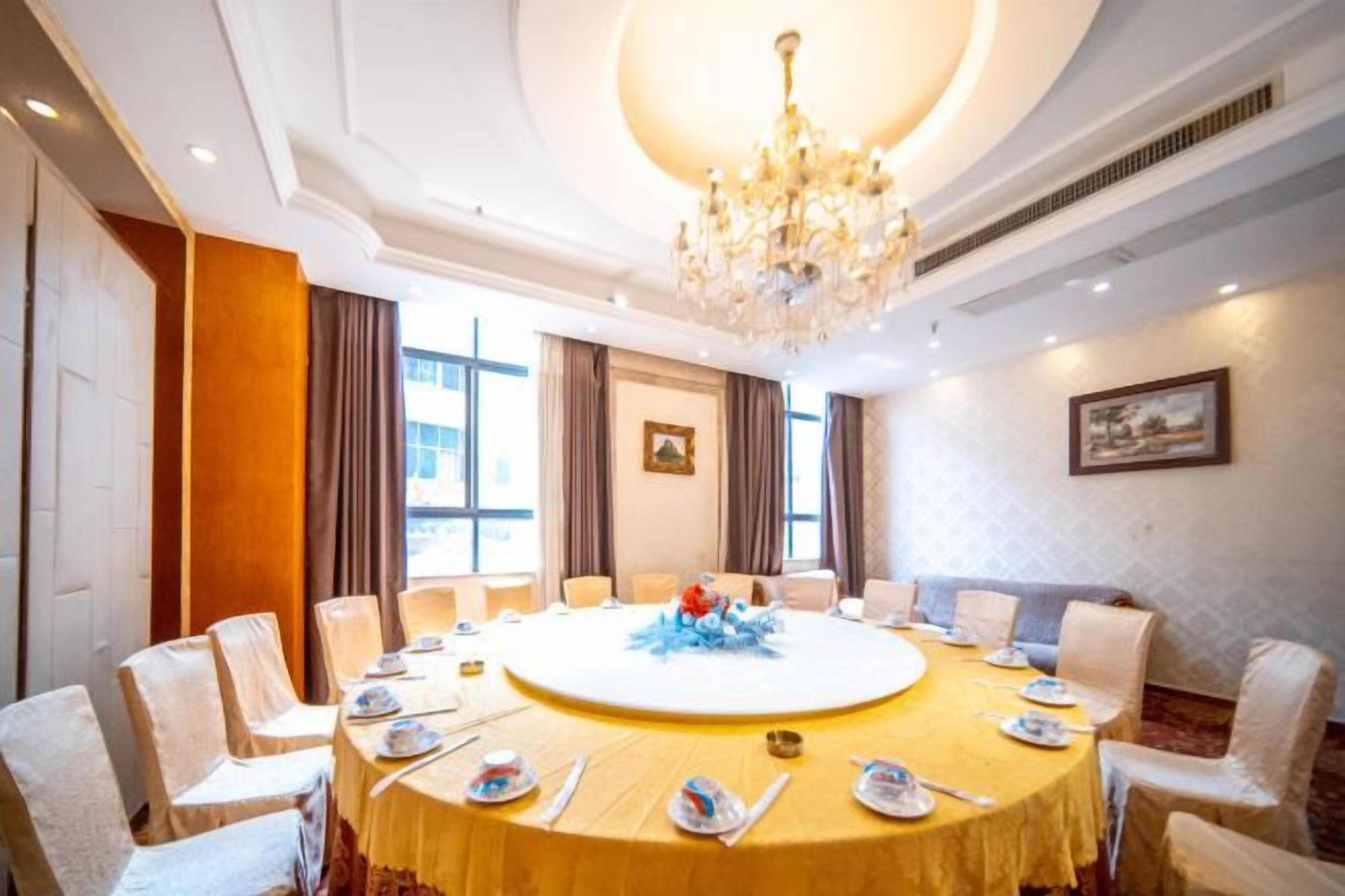 A conference room with a round table, chairs, and a chandelier.