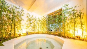 A spa area with a hot tub surrounded by bamboo plants. - Kailong Hot Spring Hotel (CHENZHOU)