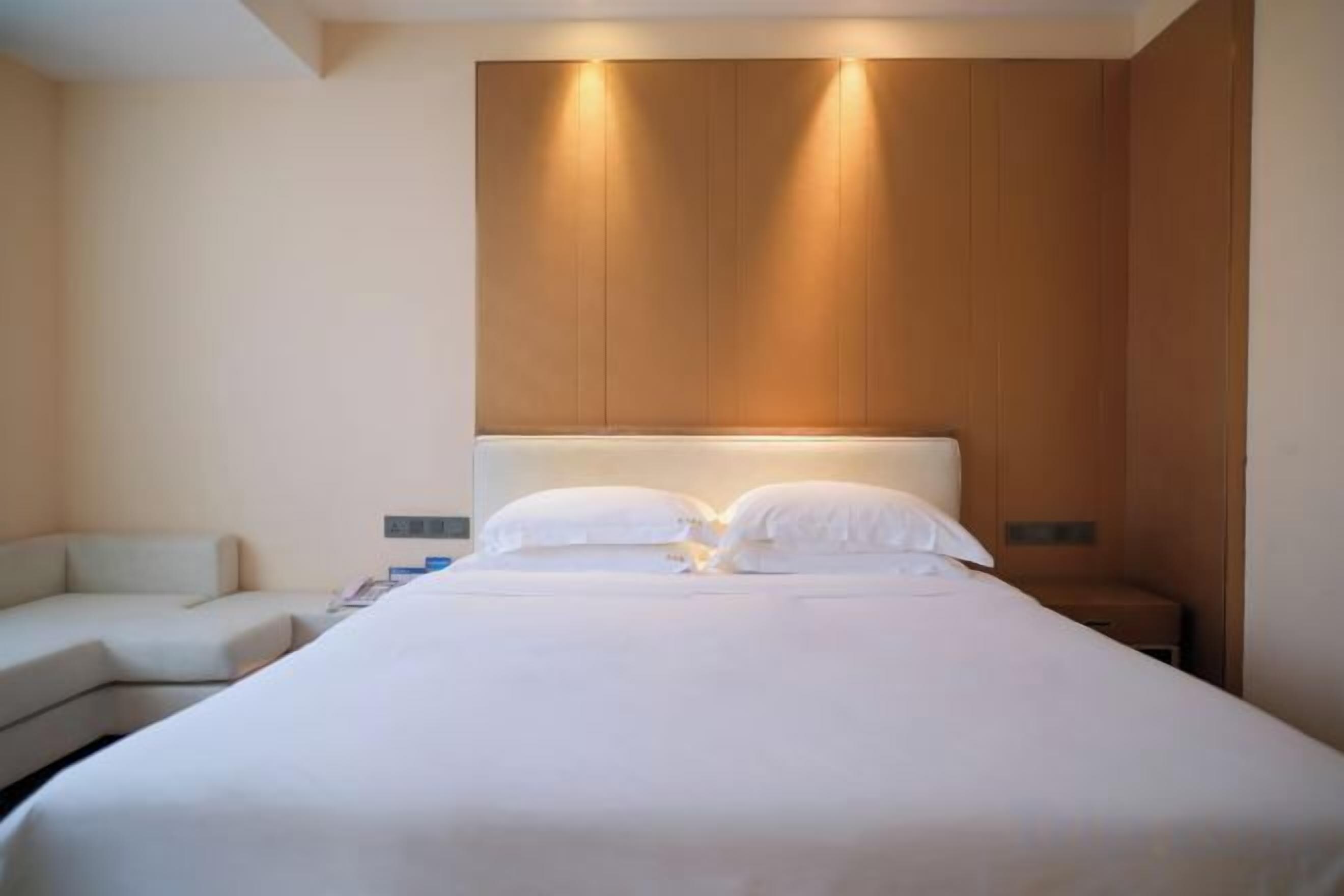 Una habitación de hotel con una cama grande, una mesita de noche y un área de descanso.