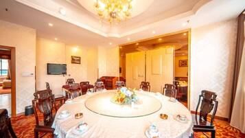 A conference room with a round table, chairs, and a chandelier.