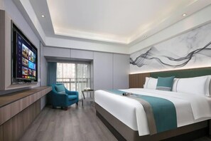 A modern hotel room with a large bed, a TV mounted on the wall, a seating area with a chair, and a window with curtains. - yilehotel rooms (Changsha)