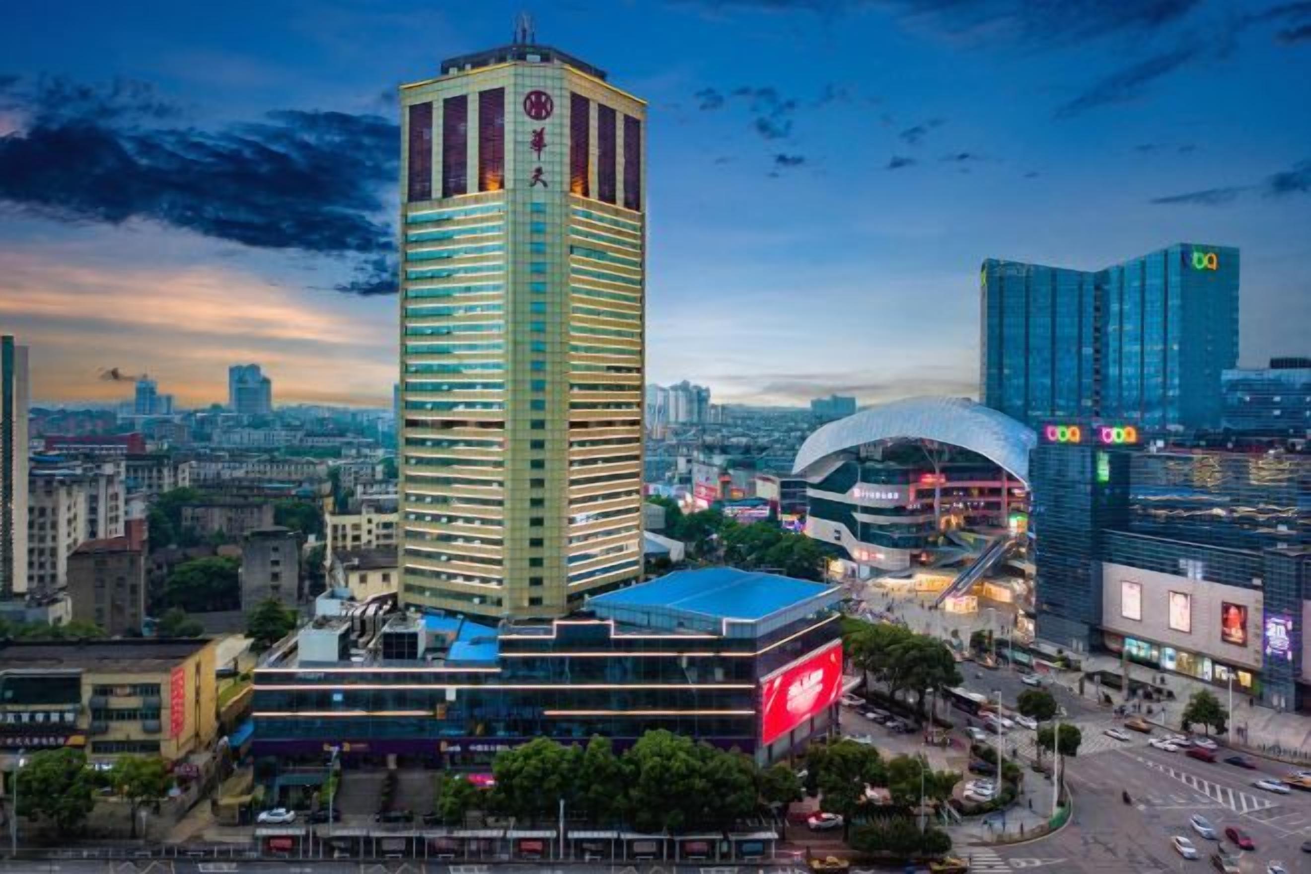 A high-rise hotel with a distinctive vertical design, surrounded by other modern buildings and a cityscape.