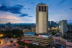 Un hotel moderno de gran altura, con una estructura vertical destacada y una fachada bien iluminada.