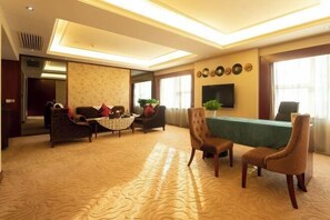A spacious room with a large table, several chairs, a sofa, and a television. - Huatian Hotel (Xiangtan)