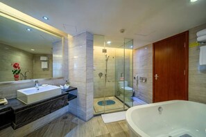 A modern bathroom with a large mirror, a bathtub, a shower, and a glass-enclosed shower area. - Huatian Hotel (Xiangtan)