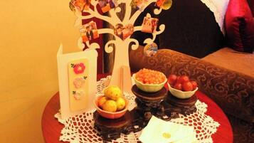 A table with a decorative tree centerpiece, bowls of fruit, and a white napkin on a doily.