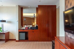 A compact hotel room with a kitchenette, a flat-screen TV, and a wardrobe. - Huatian Hotel (Xiangtan)