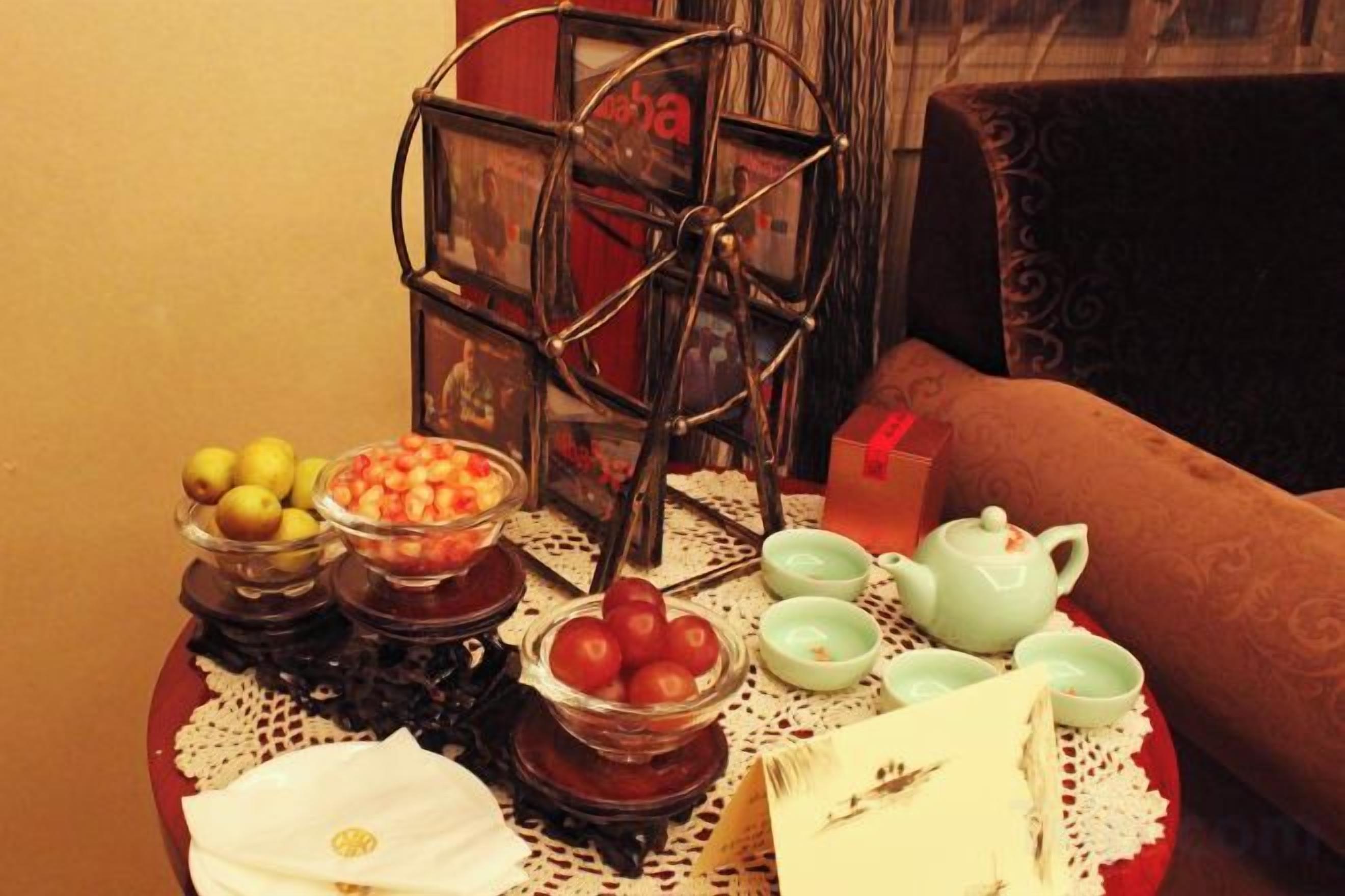 A table with various food items and a teapot, set on a lace tablecloth.