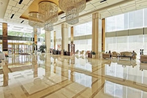 A spacious lobby with a polished floor, large windows, and multiple seating areas. - Huatian Hotel (Xiangtan)