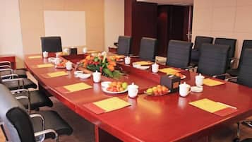 A conference room with a long table, chairs, and a floral centerpiece.