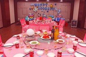 A round table with pink tablecloth, balloons, and party decorations. - Huatian Hotel (Xiangtan)