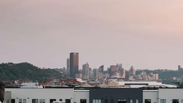 Un horizonte urbano con varios edificios, incluyendo un alto edificio destacado que muestra la palabra 'LYNCH'.