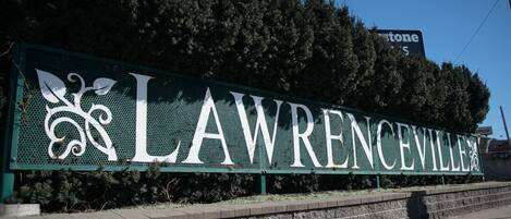 A sign with the name 'LAWRENCEVILLE' in large letters, surrounded by greenery.