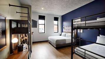 Une chambre avec des lits superposés, un bureau avec une lampe et une fenêtre donnant sur un beau paysage.