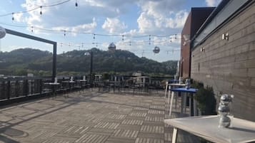 An outdoor patio with a wooden deck, string lights, and a disco ball.