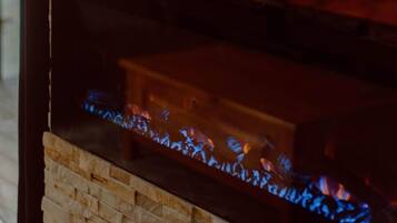 A stone fireplace with a visible fire.