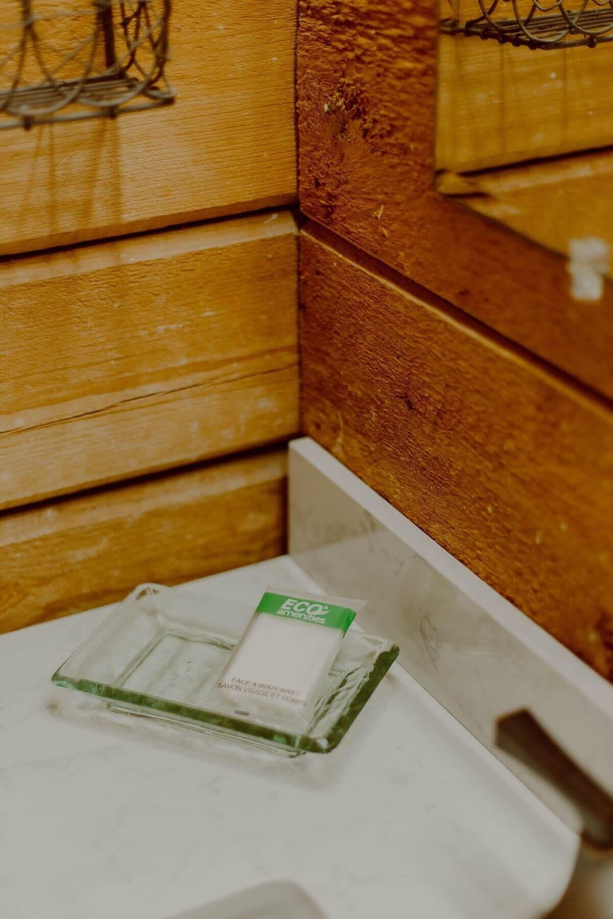 Esquina de una habitación con paneles de madera y un cubo de basura blanco.