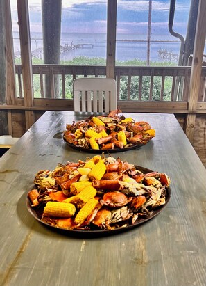 Outdoor dining - Majestic bayfront home. 450’ pier w/ boat access, crabbing, fishing, & swimming. (Grand Isle)