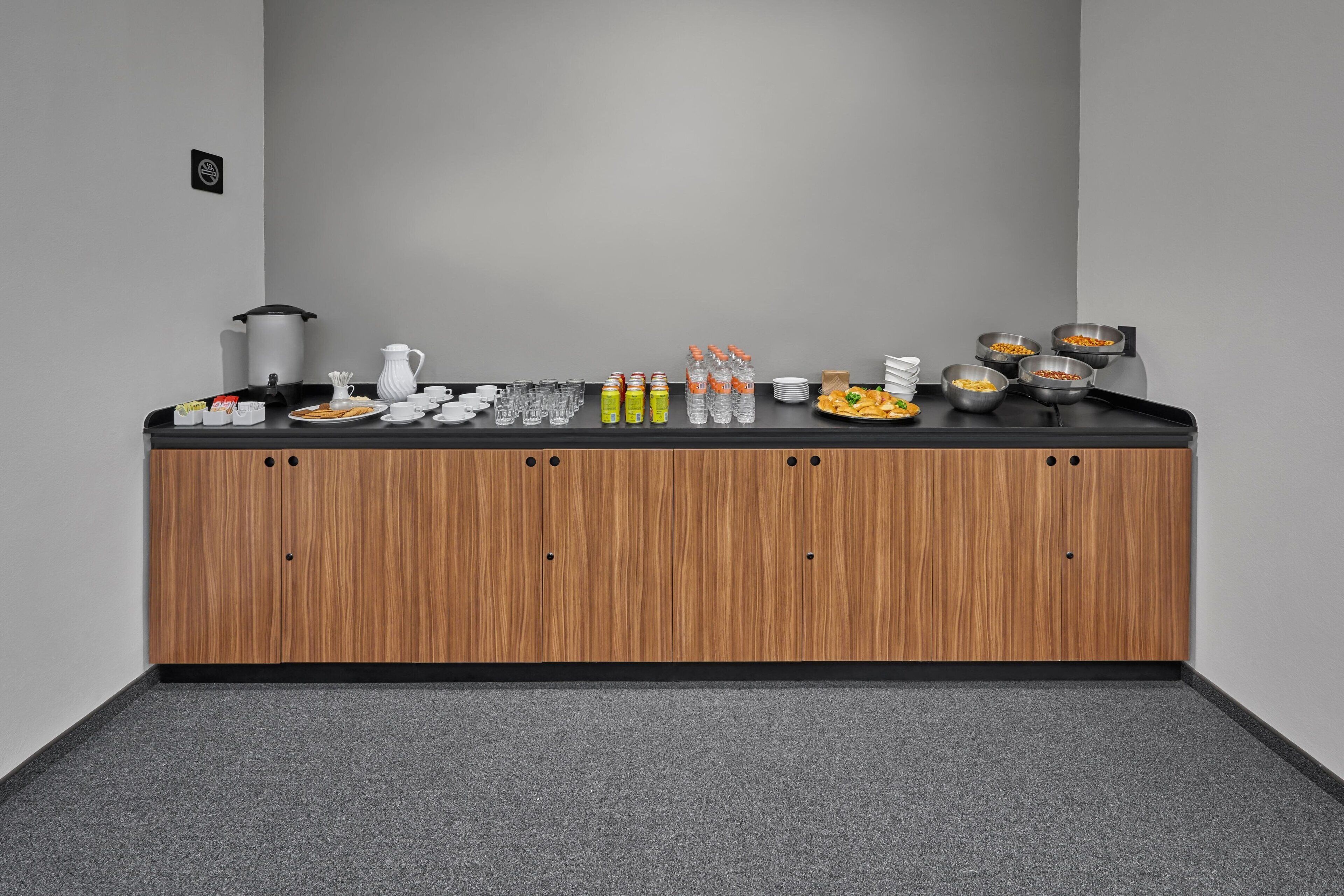A buffet setup with various food items, beverages, and a coffee station.