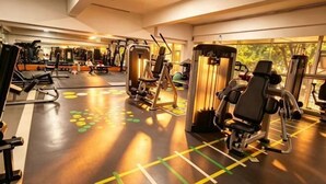 A gym with exercise equipment, mirrors, and a patterned floor.