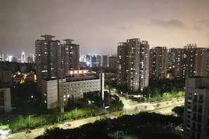 Ein hoch aufragendes Stadtgebiet bei Nacht mit beleuchteten Gebäuden und einer gut ausgeleuchteten Straße.