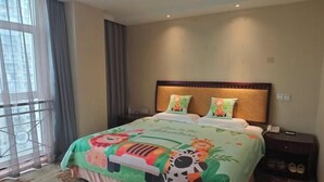 A hotel room with a bed, a nightstand, a window with curtains, and a view of buildings outside.