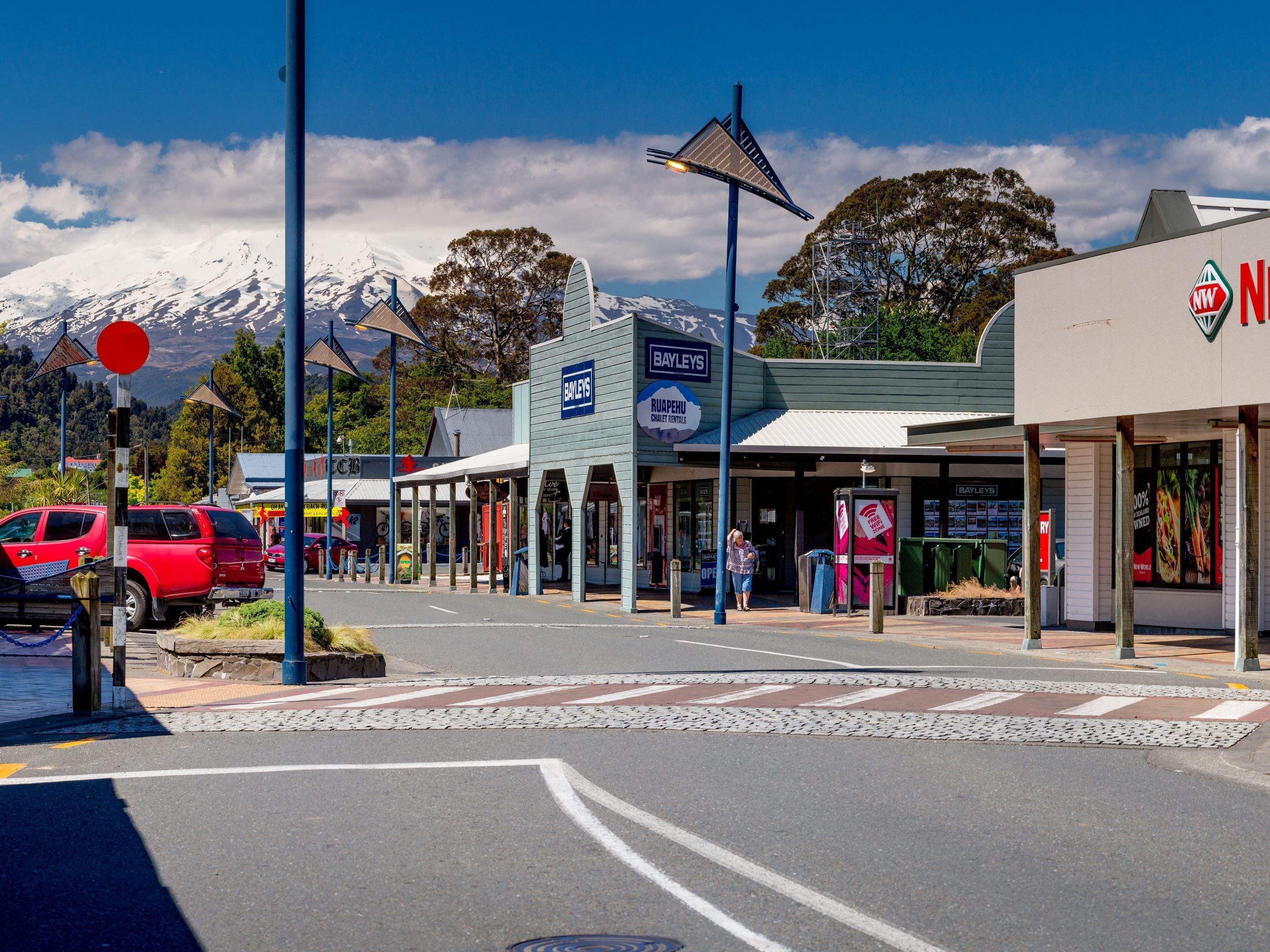Vista de la calle con una tienda Bayleys, un cartel de Ruapehu Chalet Rentals y un letrero NWT.