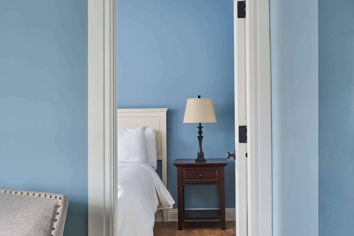 A bedroom with a bed, nightstand, and lamp.