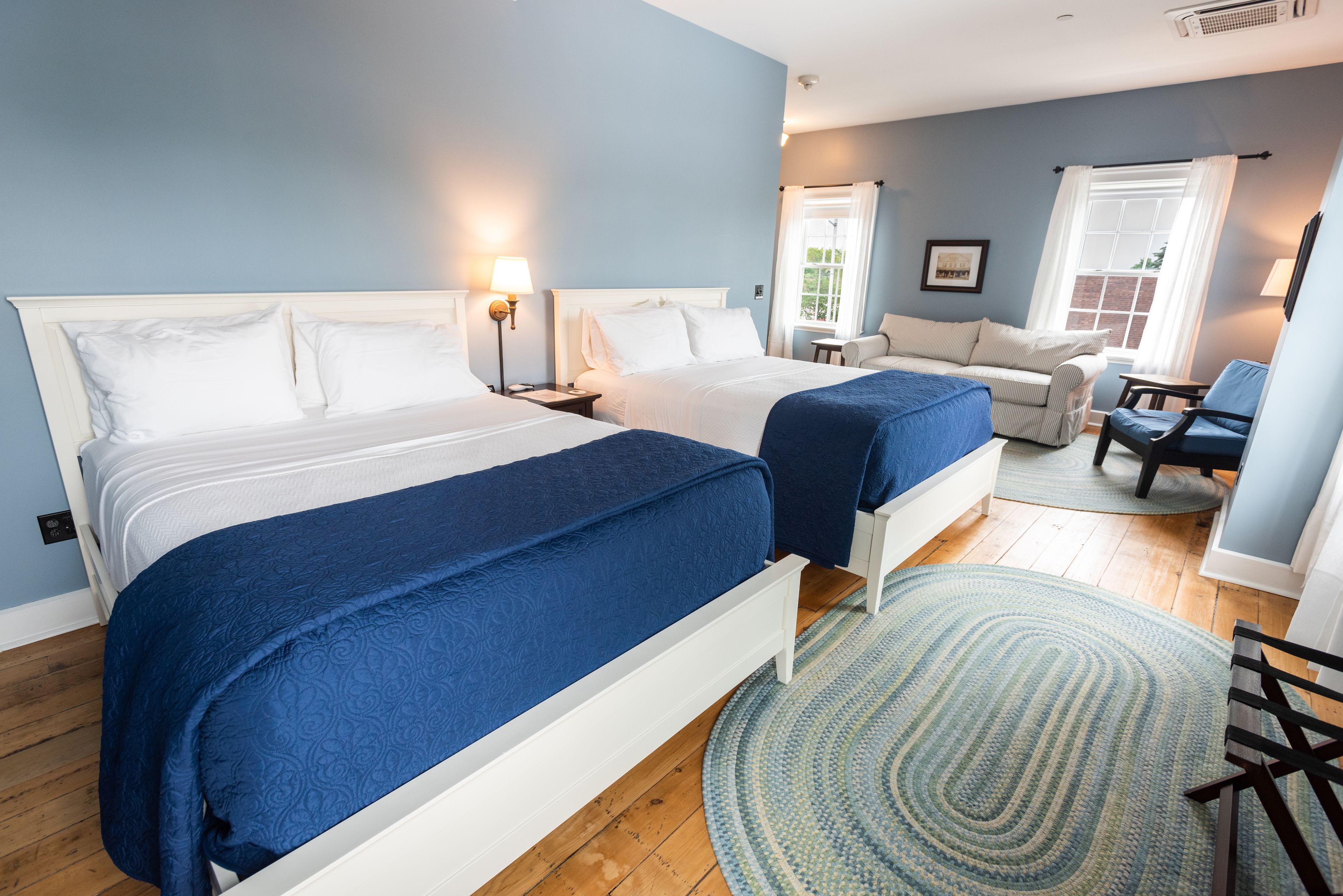 A bedroom with two beds, a sofa, and a chair.