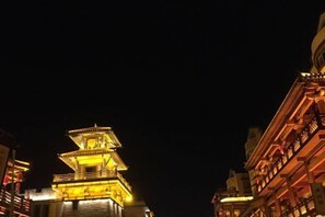 A multi-story building with a traditional architectural style, featuring a prominent tower-like structure on the left. - Hongbao Hotel (Xuchang Caowei Ancient City Pang Donglai Times Square) (Xuchang)