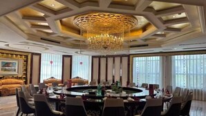 A luxurious dining room with a round table, elegant chairs, and a large chandelier. - Fengleyuan Hotel (Zhengzhou)