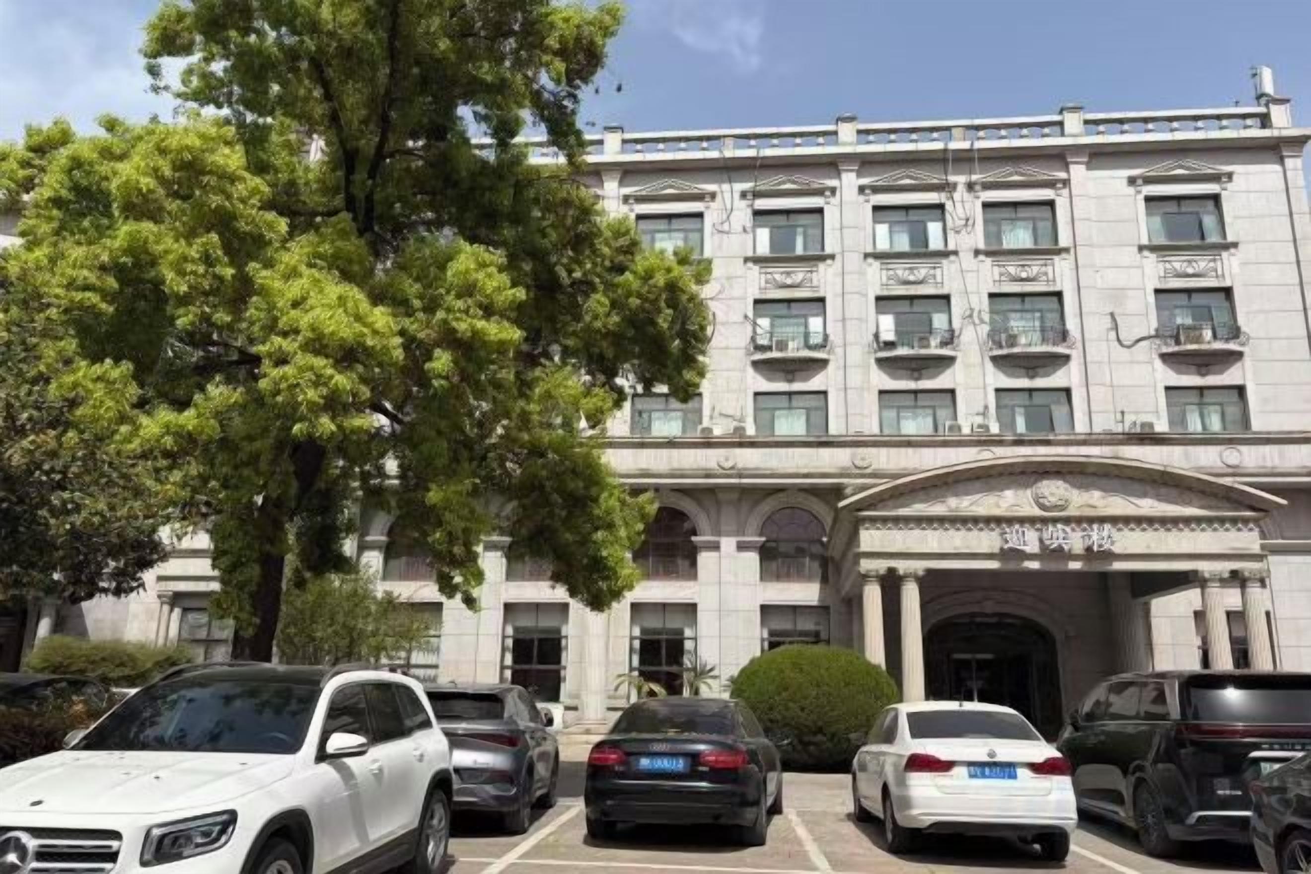 A multi-story building with a parking lot in front.