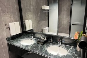 A modern bathroom with two sinks, a large mirror, and a shower area. - Fengleyuan Hotel (Zhengzhou)