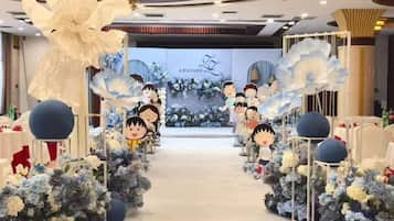 A hotel corridor with floral decorations and cartoon character cutouts.