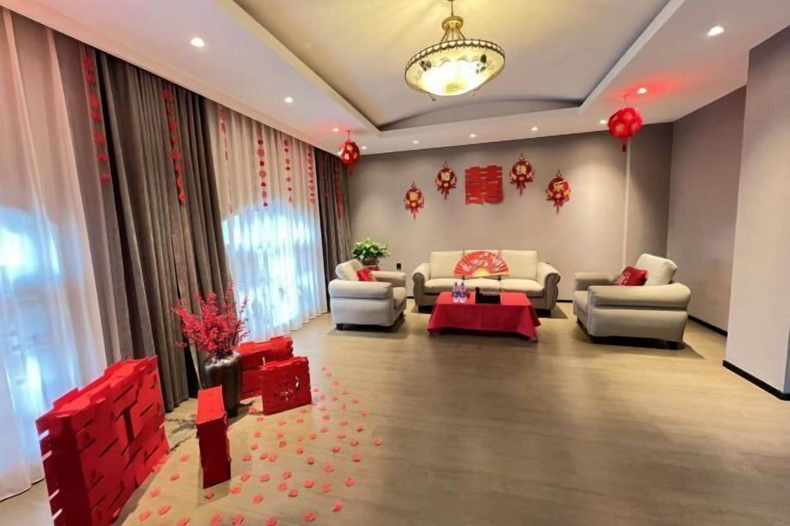 A modern living room with a sofa set, a coffee table, and decorative red elements.