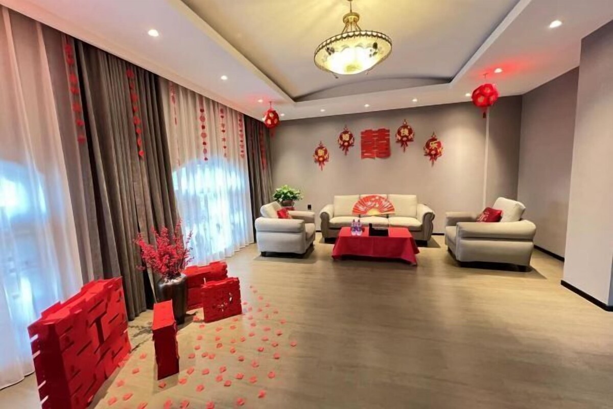 A modern living room with a sofa set, a coffee table, and decorative red elements.